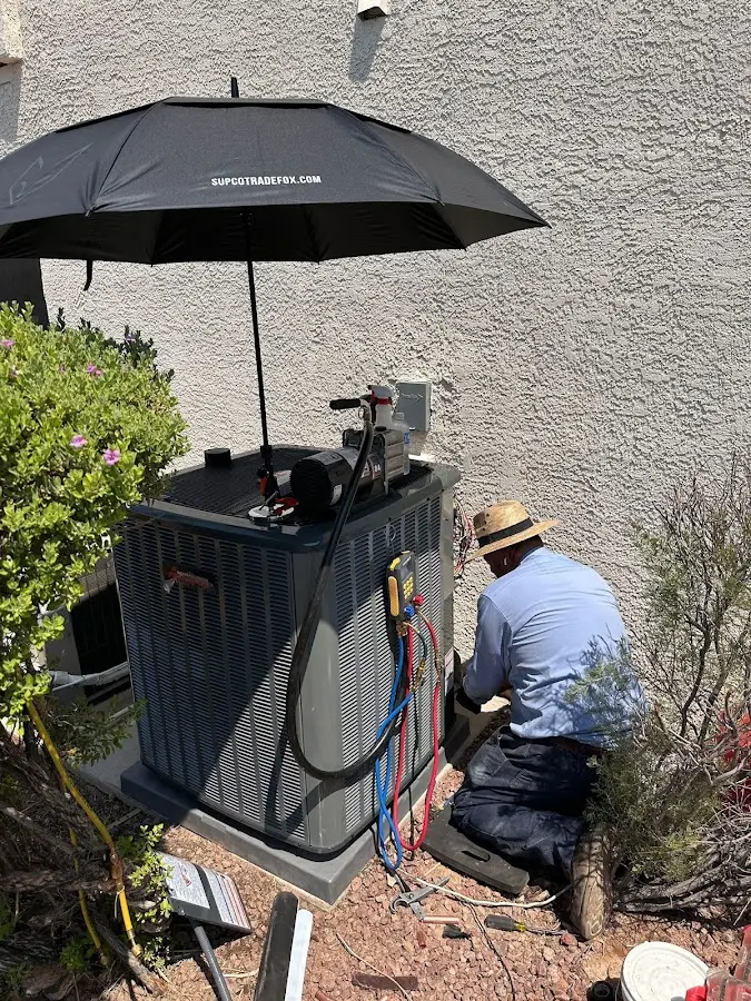 HVAC technician performing outdoor AC maintenance in Huntertown