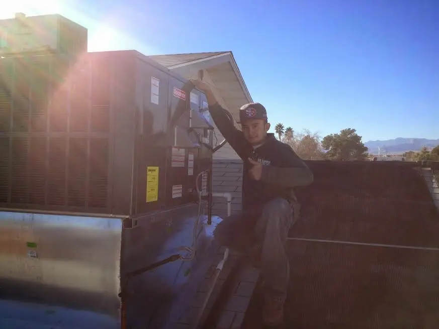 HVAC technician performing AC Tune-Up on a rooftop unit in Huntertown